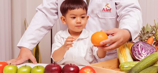 Healthy and nutrition concept. Kid learning about nutrition with doctor to choose eating fresh fruits and vegetables.Young asian boy holding orange.